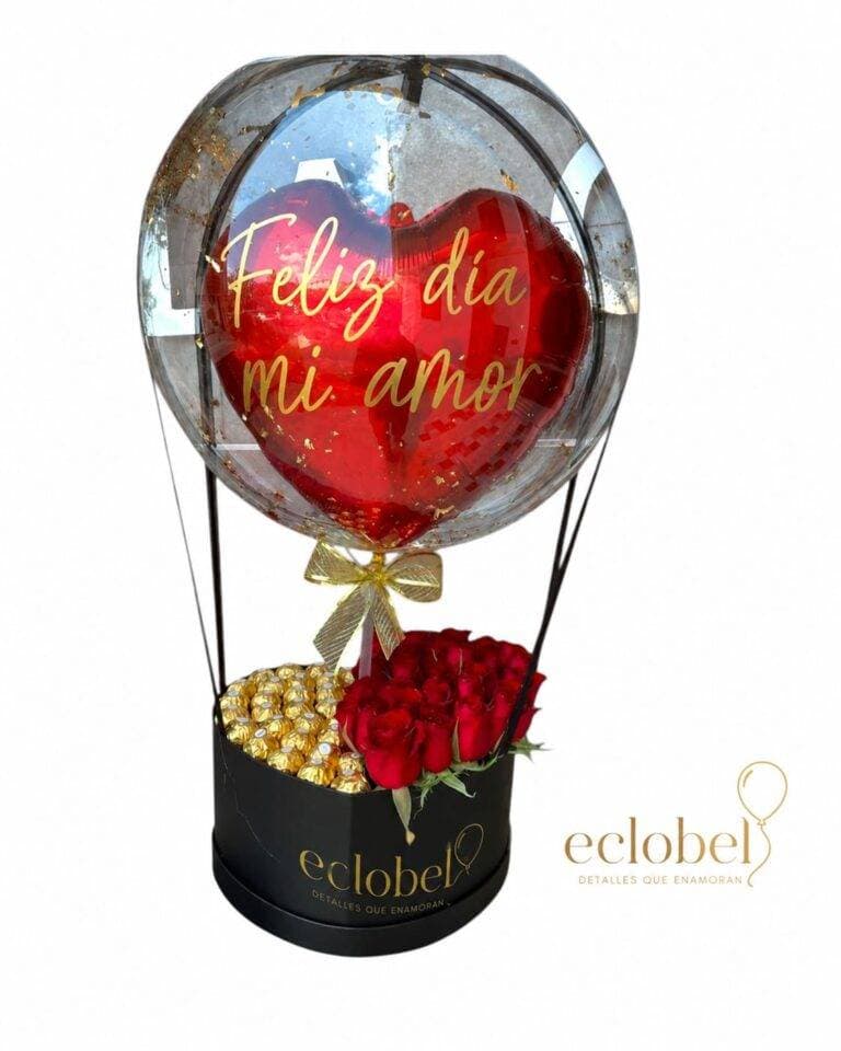 Arreglo de rosas rojas con chocolates y globo burbuja “Feliz día mi amor”